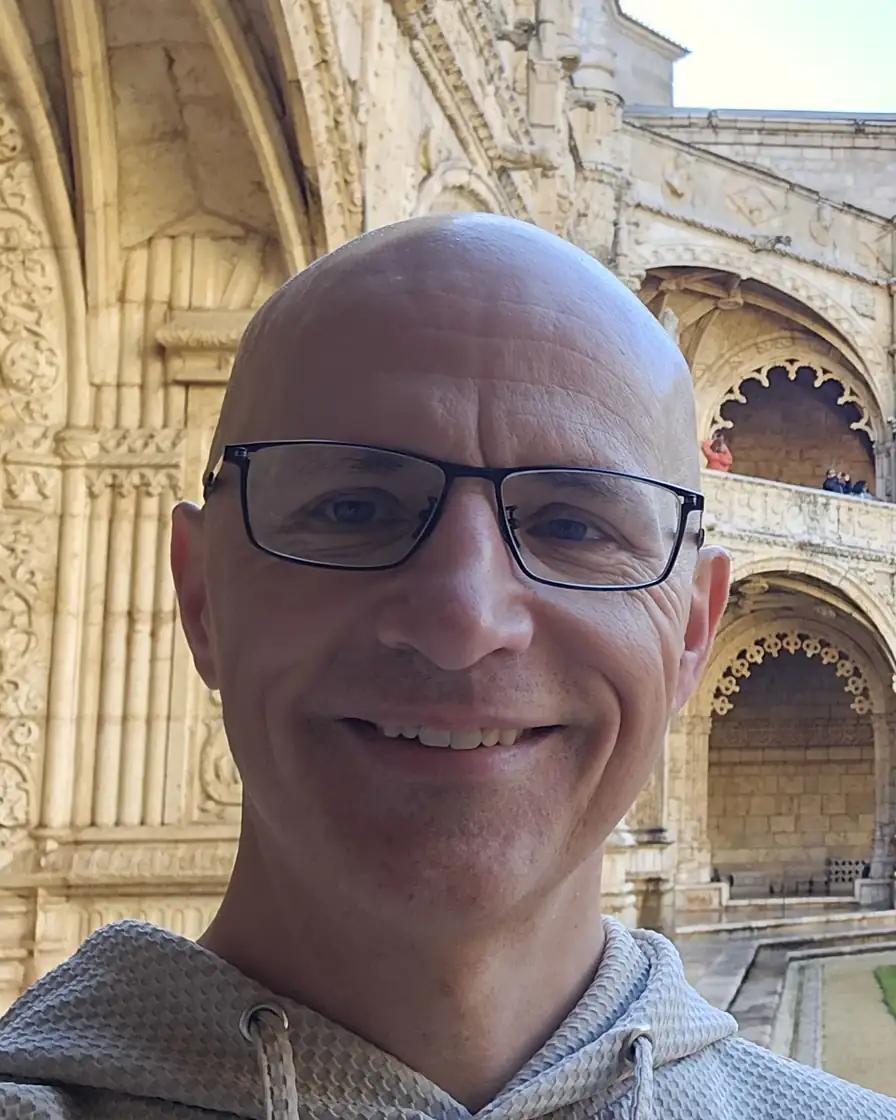 Robert Turnbull, founder of Strategic Mind, smiling in a stone cloister courtyard